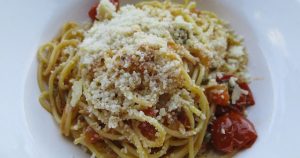 A plate of delicious pasta with cherry tomatoes and Parmesan cheese